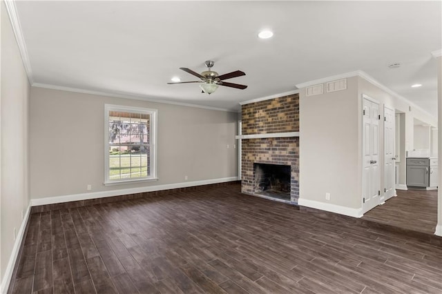 unfurnished living room with dark wood-type flooring, a brick fireplace, ornamental molding, and baseboards