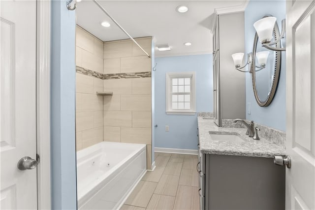 bathroom featuring a combined bath / shower with jetted tub, recessed lighting, baseboards, and vanity