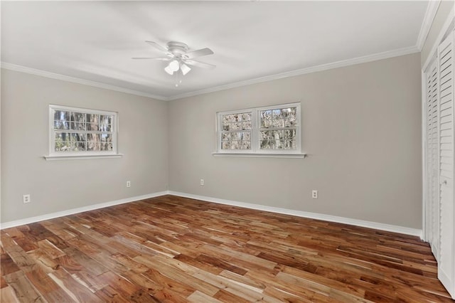 unfurnished room with a ceiling fan, crown molding, baseboards, and wood finished floors