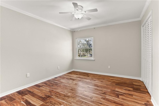 unfurnished bedroom featuring baseboards, wood finished floors, and crown molding