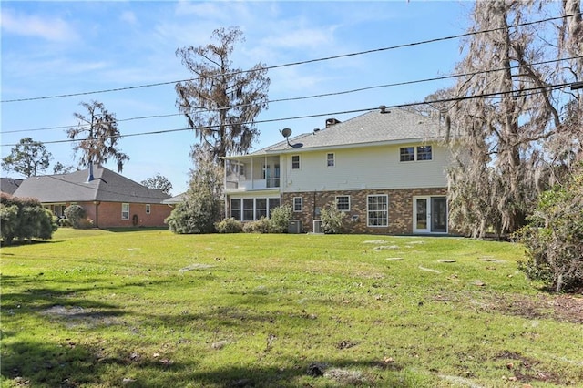 rear view of house with brick siding and a lawn