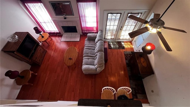 living area featuring french doors, a tiled fireplace, and wood finished floors