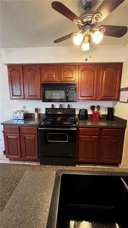 kitchen with dark countertops, black appliances, a ceiling fan, and a textured ceiling