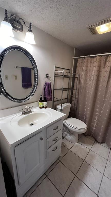 full bath featuring tile patterned flooring, visible vents, a textured ceiling, and vanity