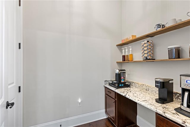 interior space featuring baseboards and dark wood-style flooring