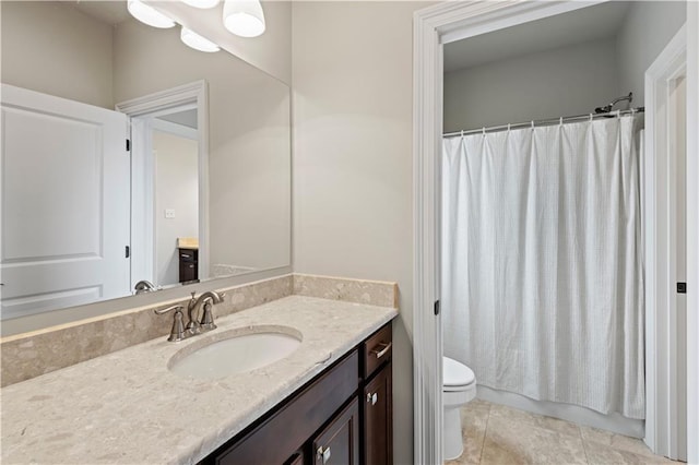 bathroom with tile patterned flooring, vanity, and toilet