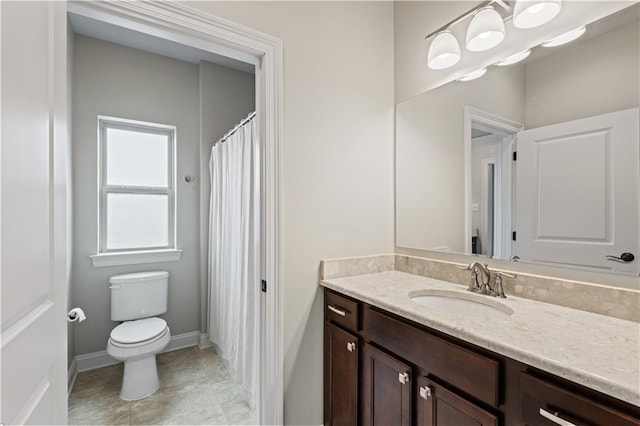 bathroom featuring toilet, baseboards, and vanity