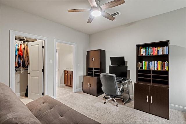 home office with baseboards, a ceiling fan, visible vents, and light colored carpet