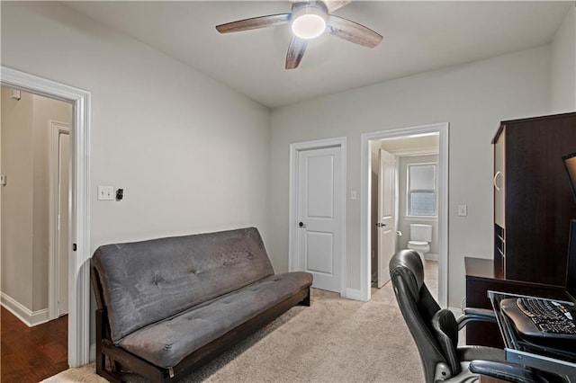 carpeted home office featuring a ceiling fan and baseboards