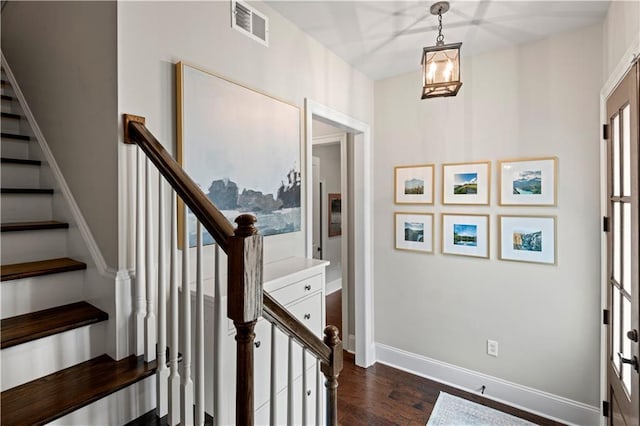 stairs with visible vents, baseboards, and wood finished floors