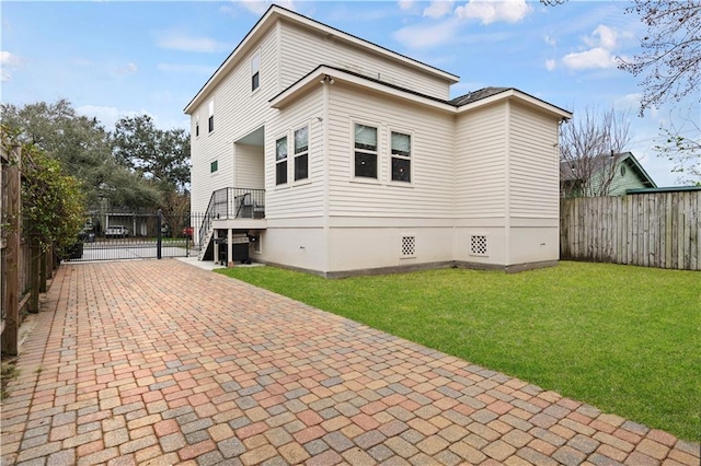 exterior space featuring central AC unit, crawl space, a gate, fence, and a yard