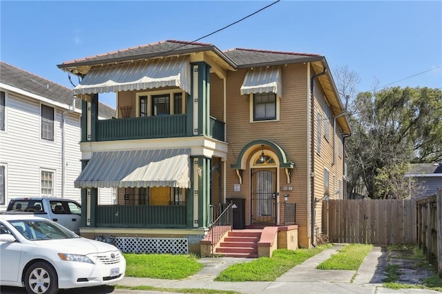 view of property featuring fence and a balcony