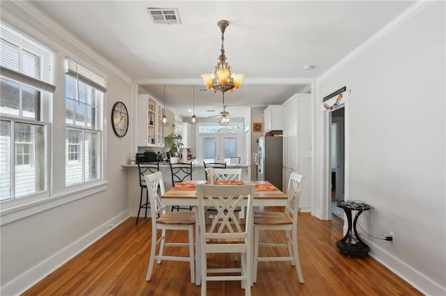 dining area with baseboards, wood finished floors, and french doors