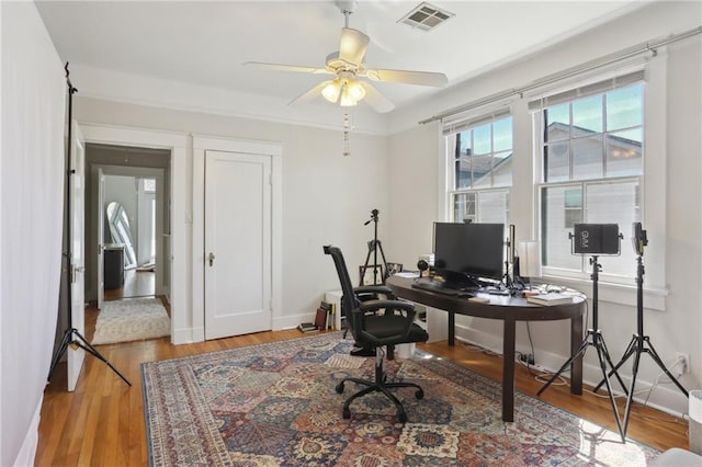 home office with visible vents, baseboards, and wood finished floors