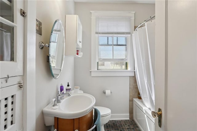 bathroom featuring shower / bath combination with curtain, toilet, vanity, baseboards, and tile patterned floors