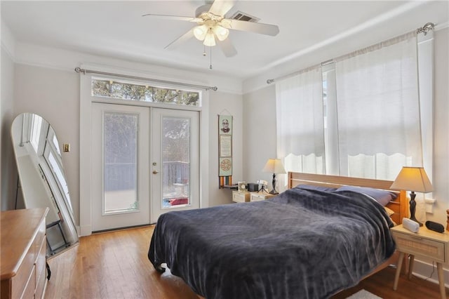 bedroom featuring ceiling fan, wood finished floors, visible vents, access to outside, and french doors