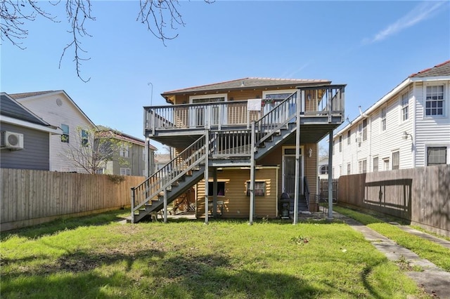 back of house featuring stairway, a lawn, a fenced backyard, and a wooden deck