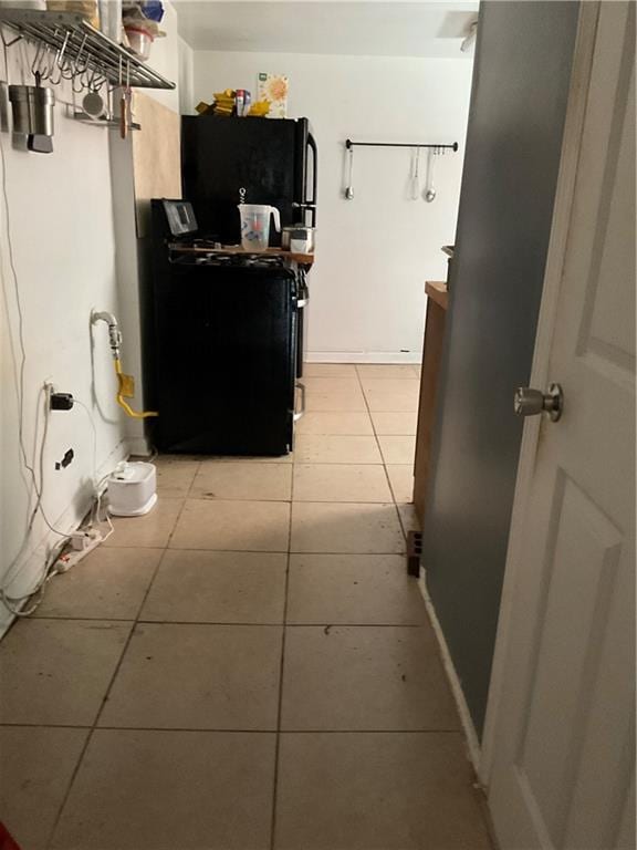 2909 1st St, New Orleans, LA 70113 - interior space featuring light tile patterned flooring, range with gas stovetop, and freestanding refrigerator