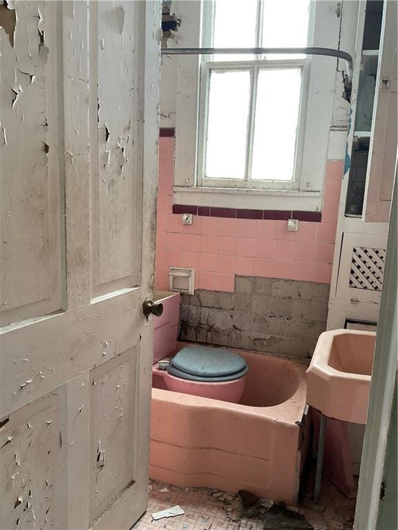 2909 1st St, New Orleans, LA 70113 - full bath with toilet, a tub, and tile walls