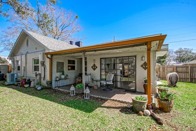 view of front of property with cooling unit, brick siding, fence, a front lawn, and a chimney