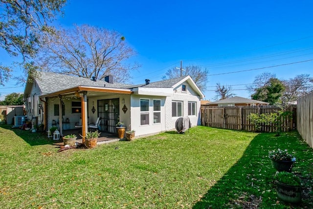 rear view of property with central air condition unit, fence, a lawn, and brick siding