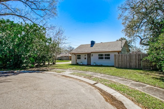 view of front of home featuring a shingled roof, a chimney, fence, and a front lawn