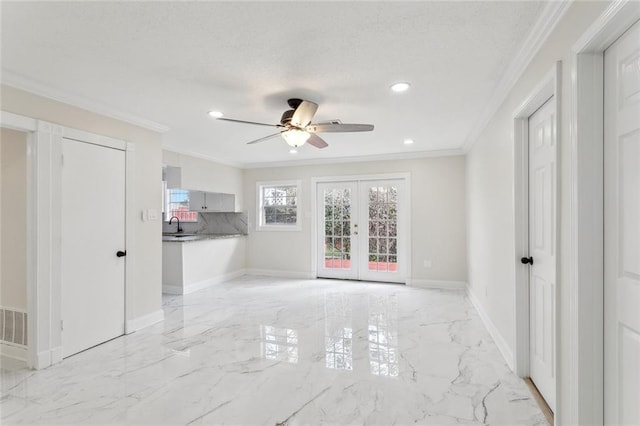 spare room featuring baseboards, ornamental molding, marble finish floor, french doors, and a sink