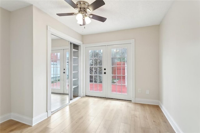 entryway featuring french doors, a ceiling fan, a textured ceiling, light wood-type flooring, and baseboards