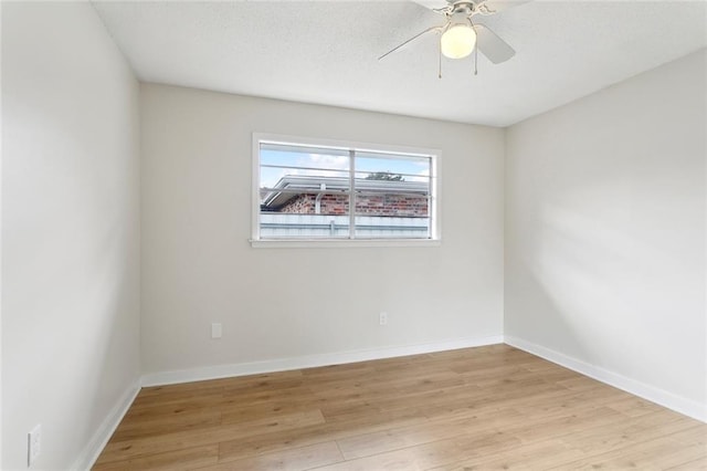 unfurnished room with baseboards, a textured ceiling, a ceiling fan, and light wood-style floors