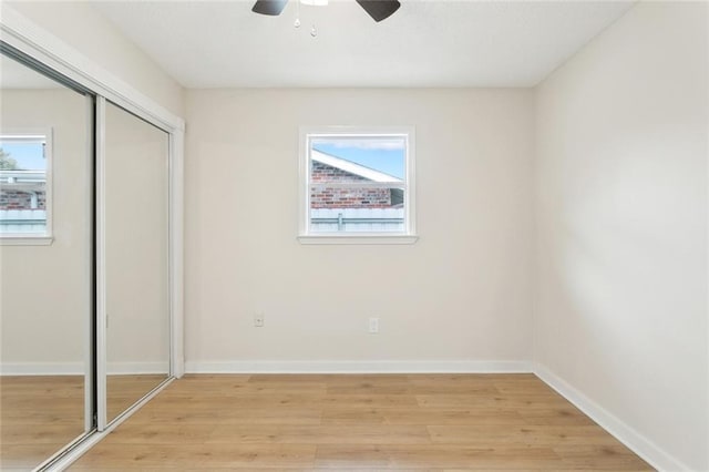 unfurnished bedroom with baseboards, ceiling fan, a closet, and light wood-style floors