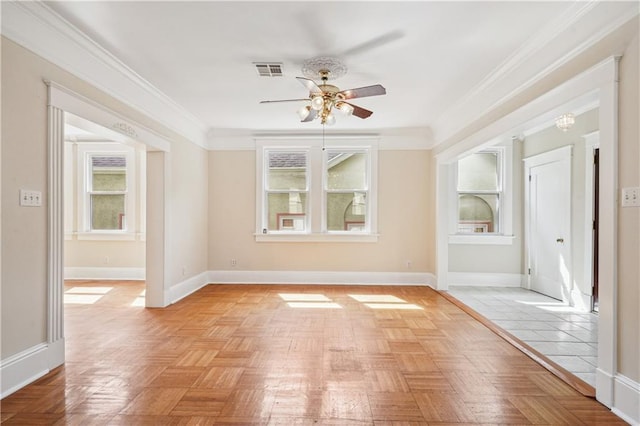 unfurnished room with visible vents, crown molding, baseboards, and ceiling fan