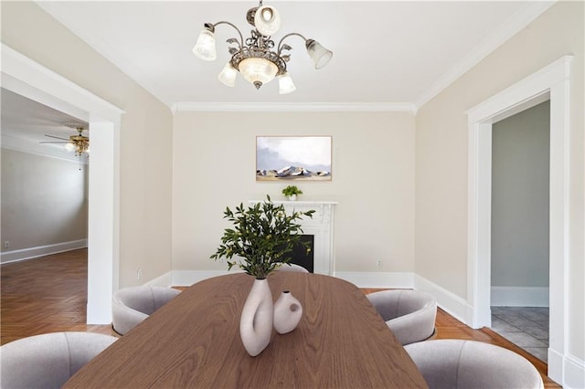 dining area featuring baseboards, a high end fireplace, wood finished floors, crown molding, and ceiling fan with notable chandelier