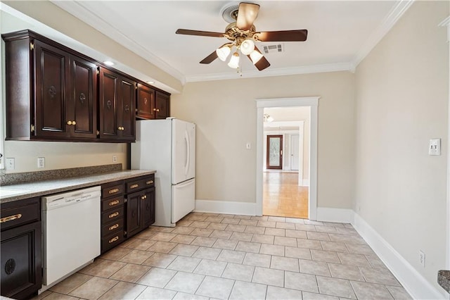 kitchen featuring light tile patterned floors, ornamental molding, dark brown cabinetry, white appliances, and baseboards