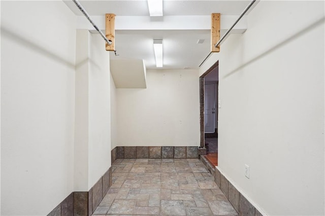 walk in closet with stone finish floor