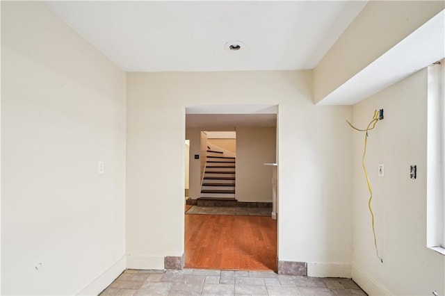 hallway with stairs and baseboards