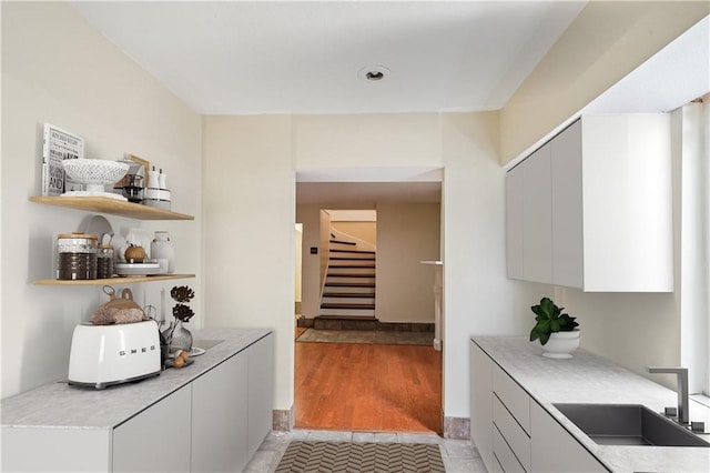 interior space with stairs, light wood finished floors, and a sink