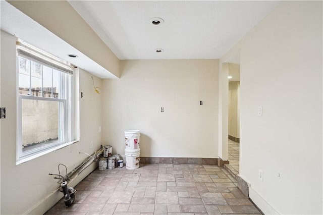 empty room with baseboards and stone finish floor