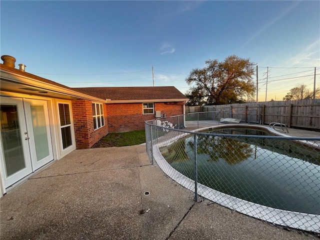 view of swimming pool with a fenced in pool, a fenced backyard, and a patio