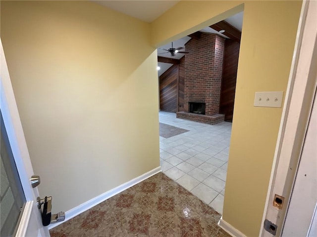 hall featuring vaulted ceiling with beams, tile patterned flooring, and baseboards