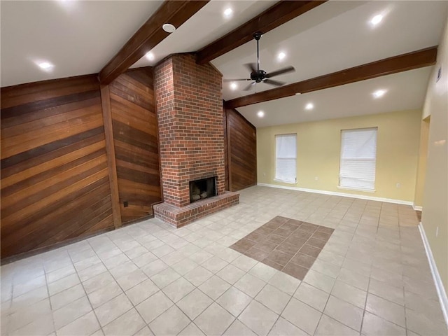 unfurnished living room featuring vaulted ceiling with beams, wooden walls, a ceiling fan, baseboards, and a brick fireplace