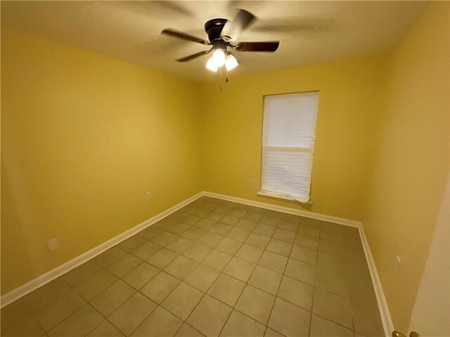 unfurnished room with ceiling fan, light tile patterned floors, and baseboards