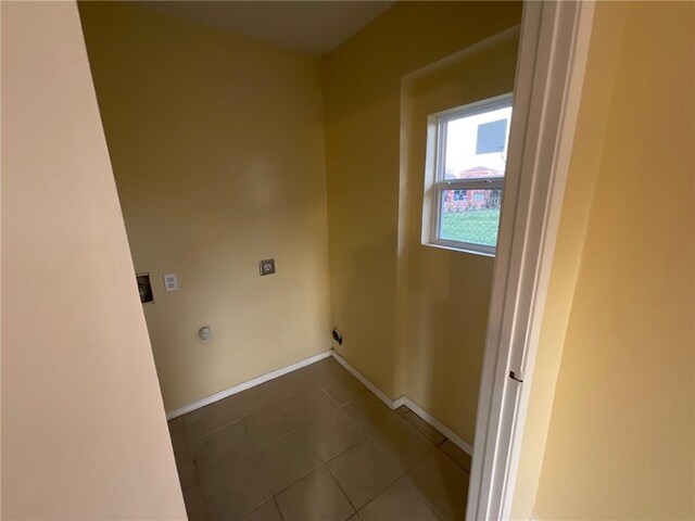 washroom featuring dark tile patterned flooring, laundry area, electric dryer hookup, and baseboards