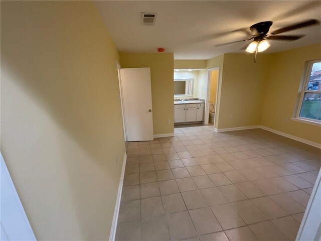 unfurnished room featuring baseboards, visible vents, a ceiling fan, and light tile patterned flooring