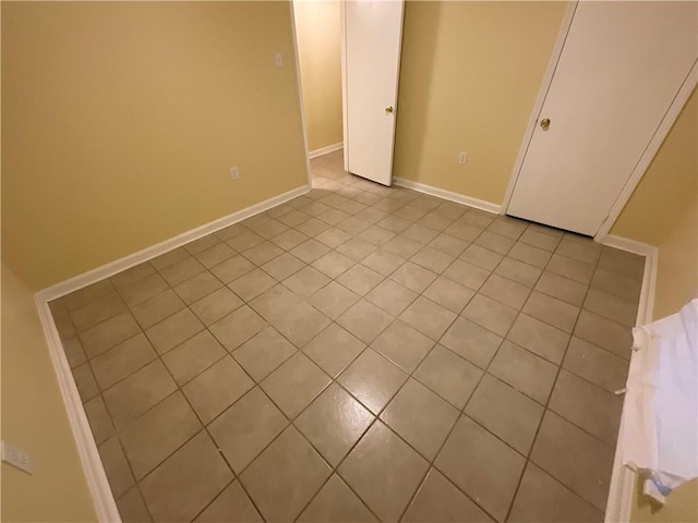 unfurnished bedroom with tile patterned flooring and baseboards