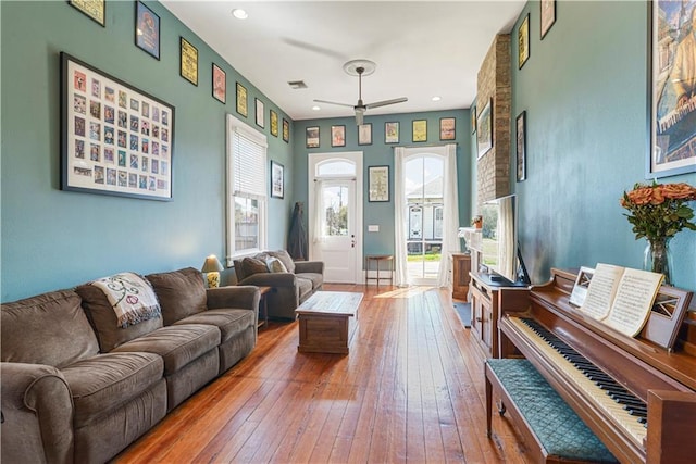 living room with ceiling fan, visible vents, hardwood / wood-style floors, and recessed lighting