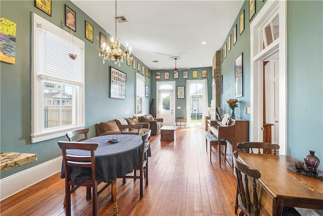 dining area with a wealth of natural light, baseboards, visible vents, and hardwood / wood-style floors