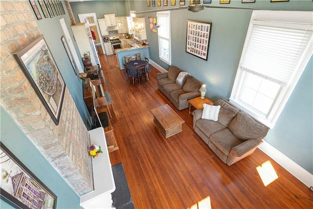 living room with a fireplace, baseboards, and wood finished floors