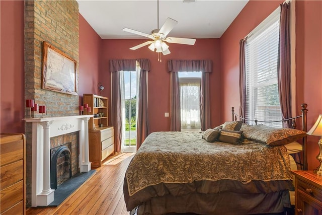 bedroom with a fireplace, visible vents, and light wood-style floors