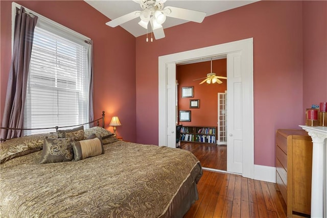 bedroom with dark wood-style floors, ceiling fan, and baseboards