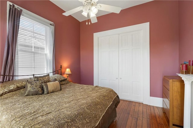 bedroom with a ceiling fan, a closet, dark wood finished floors, and baseboards